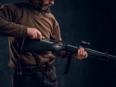 Opening of the spring hunting season. A man cleans rifle barrel, maintenance before hunting. Closeup on hands